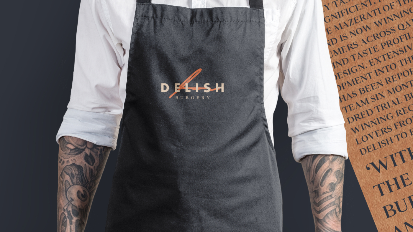 A man wearing a Delish Burgery Branded Apron