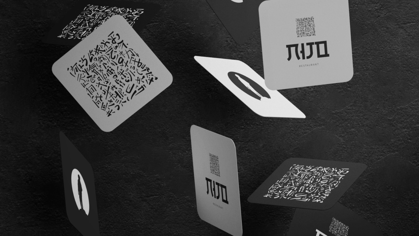 Coasters featuring Nijo restaurant's logo and abstract Japanese characters, floating in mid-air.