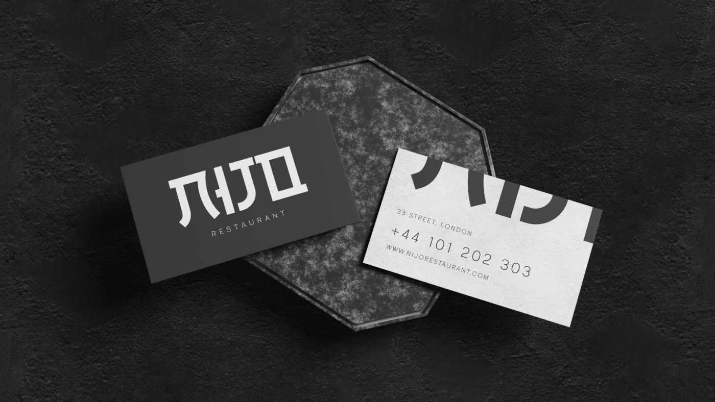 Nijo restaurant business cards on a textured surface, showcasing the logo and contact information.
