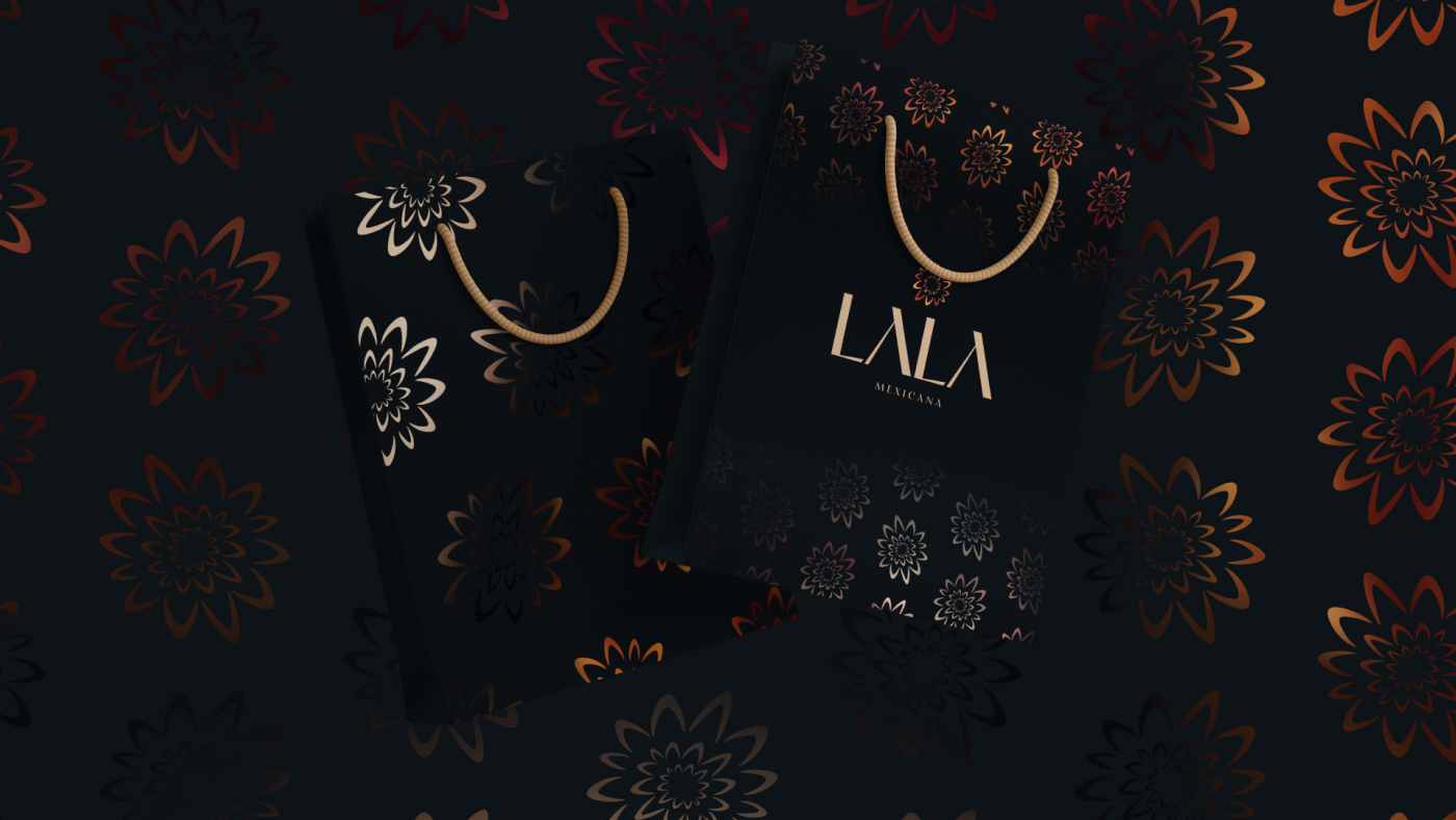 Lala Mexicana shopping bags with a floral pattern on a dark background, showcasing the brand's elegant design.