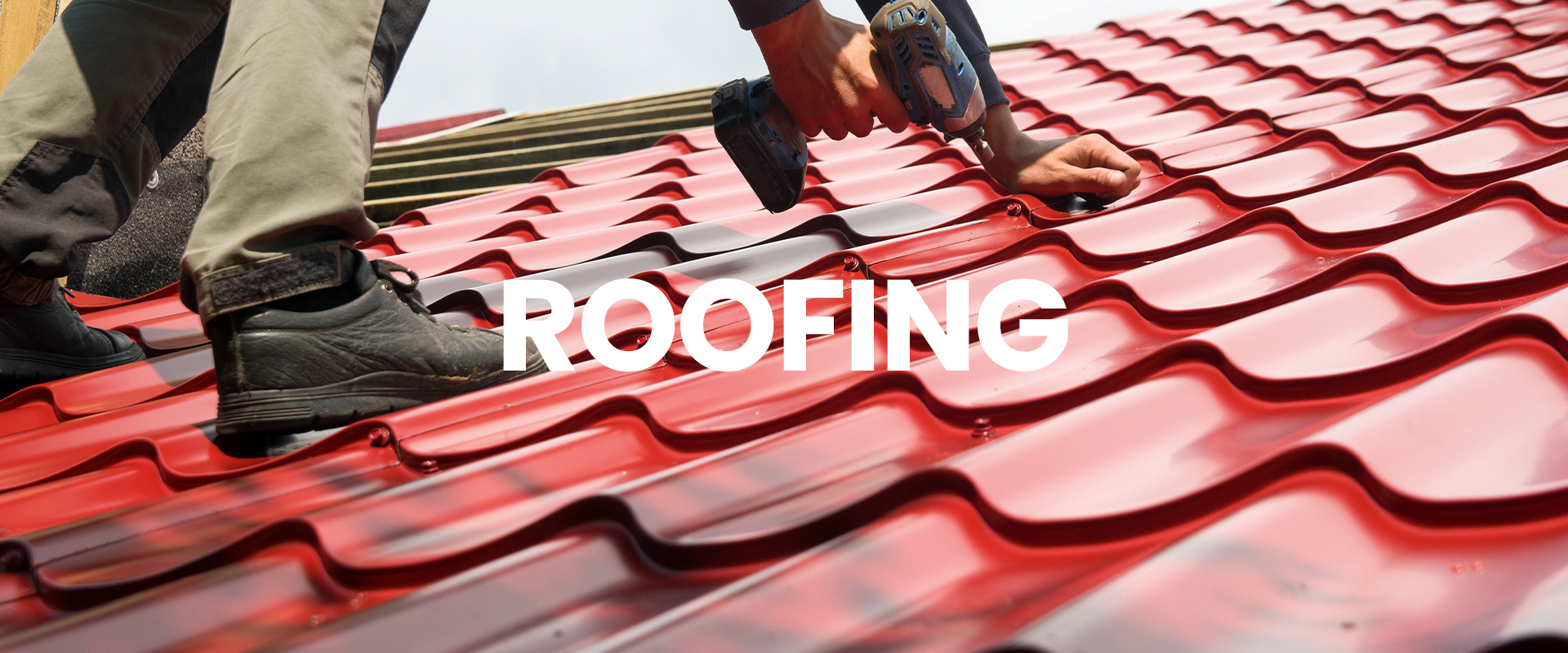 Roofer on metal roof installing