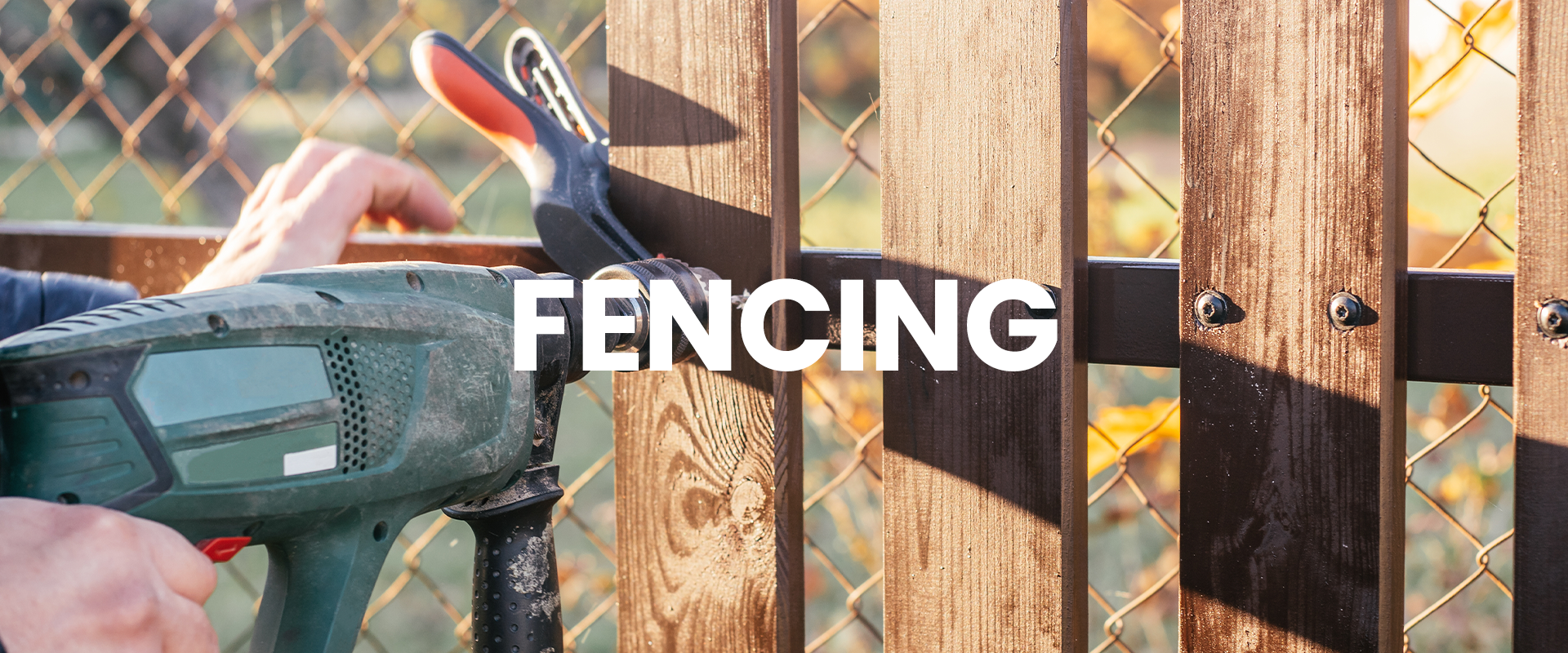 photo of fence installation, with planks being secured with the proper tools