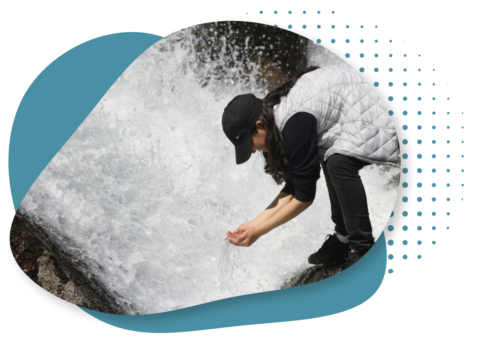 Image of woman crouching over a waterfall stream with her hands cupped to catch water.