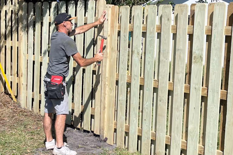 handyman fixing fence