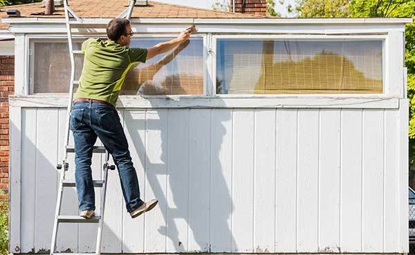 man-leaning-dangerously-on-ladder-when-painting.jpg