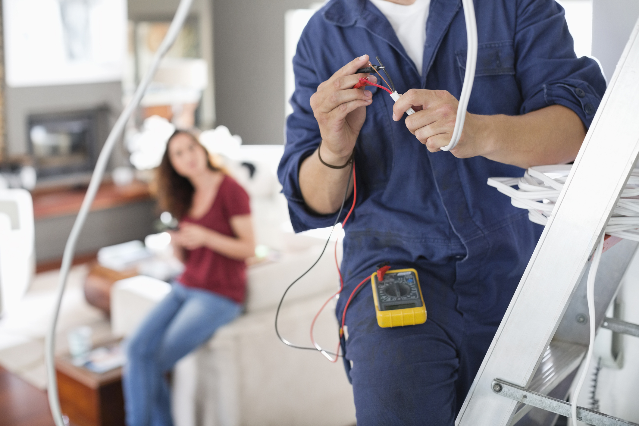 Electrician inspecting a home switchboard for wiring safety issues in New Zealand