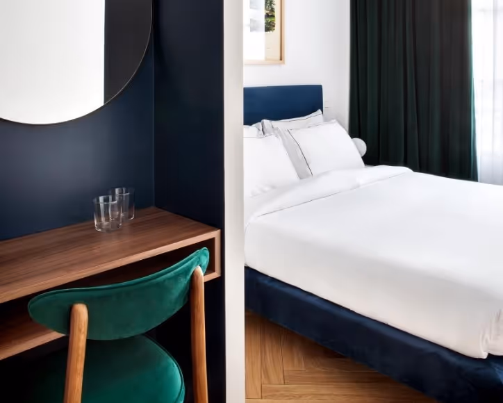 Lit double de la chambre supérieure de l’hôtel Rendez-Vous Batignolles avec tête de lit bleue