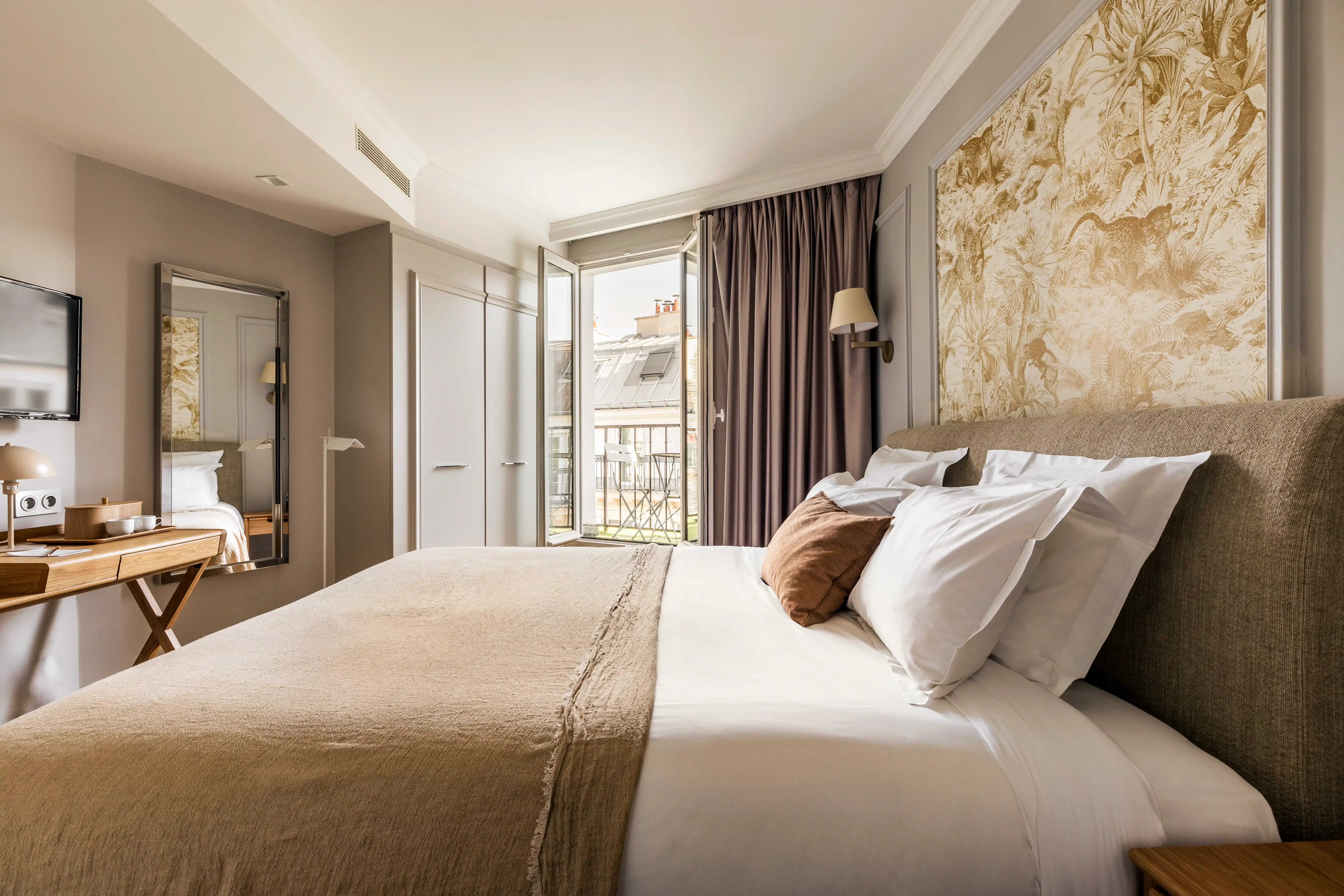 Chambre élégante de l’hôtel Maison Pigalle avec lit double et balcon lumineux