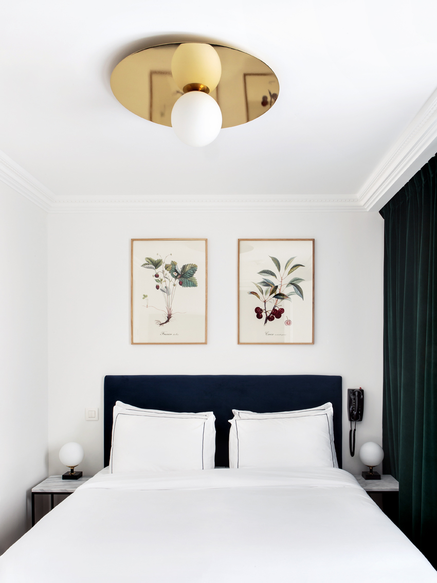 Lit double de l’hôtel Rendez-Vous Batignolles avec décoration minimaliste et cadre raffiné