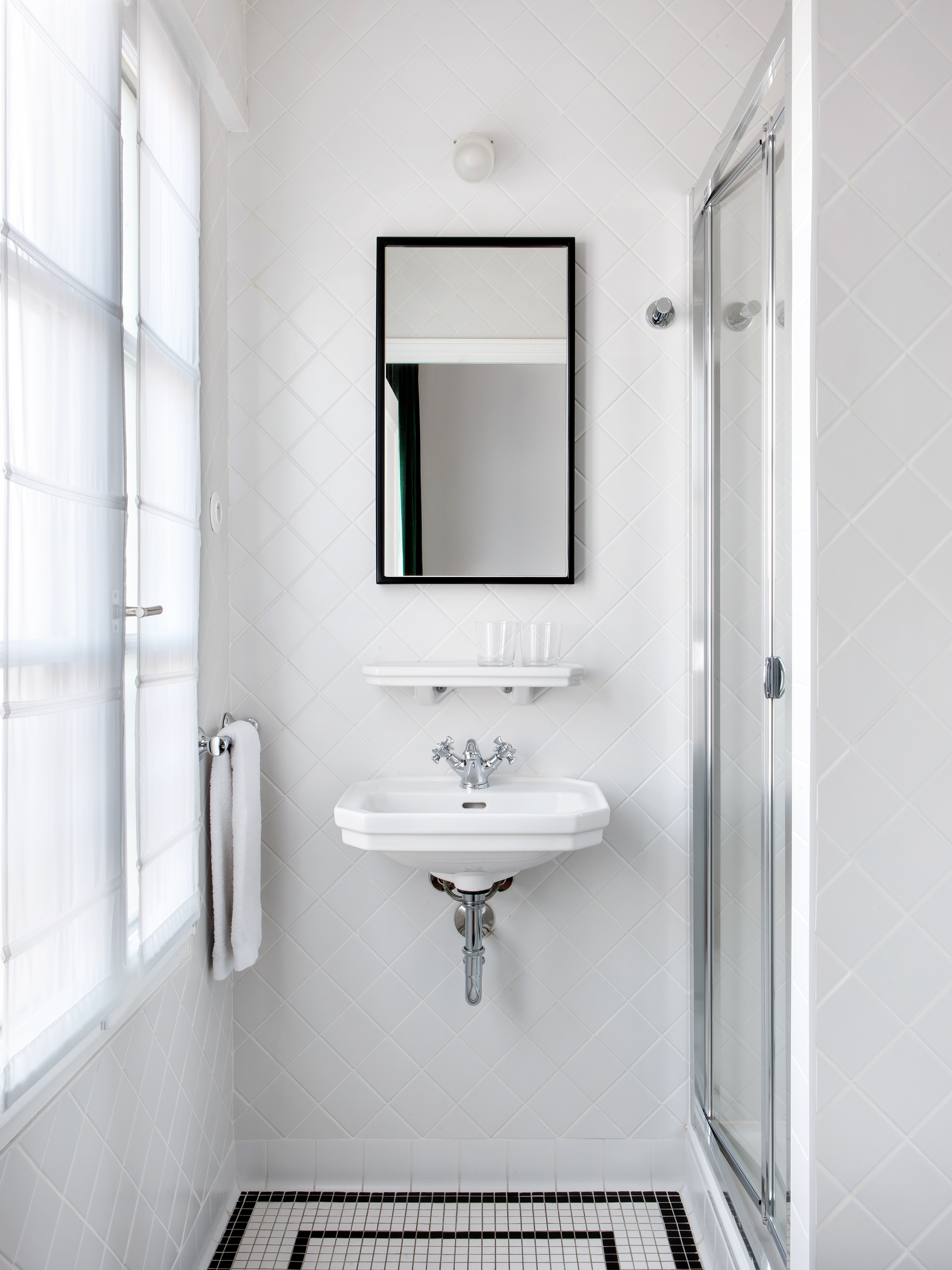 Salle de bain de l’hôtel Rendez-Vous Batignolles avec douche moderne et lavabo blanc