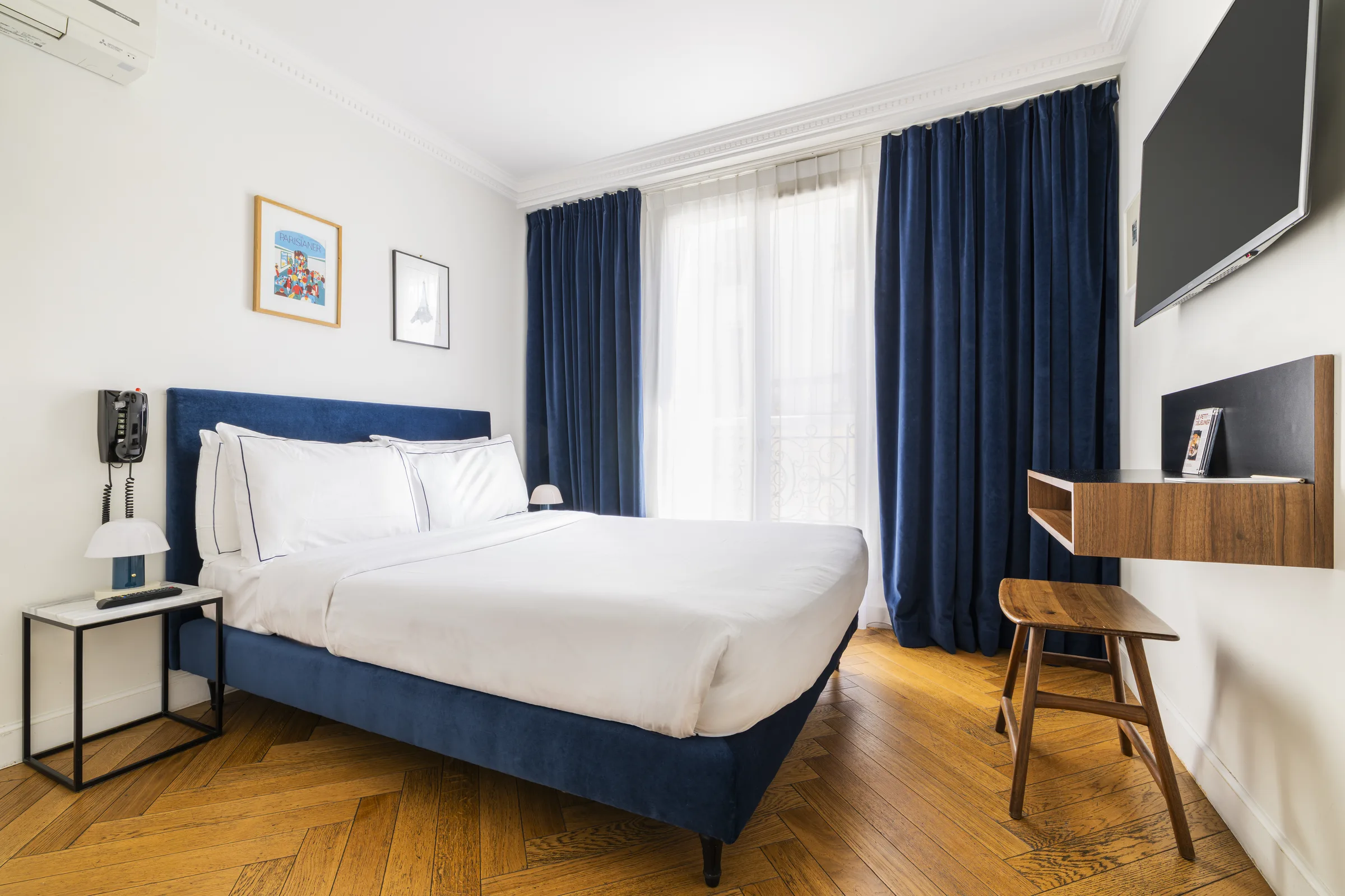 Chambre Confort avec rideaux velours bleu et parquet chevrons