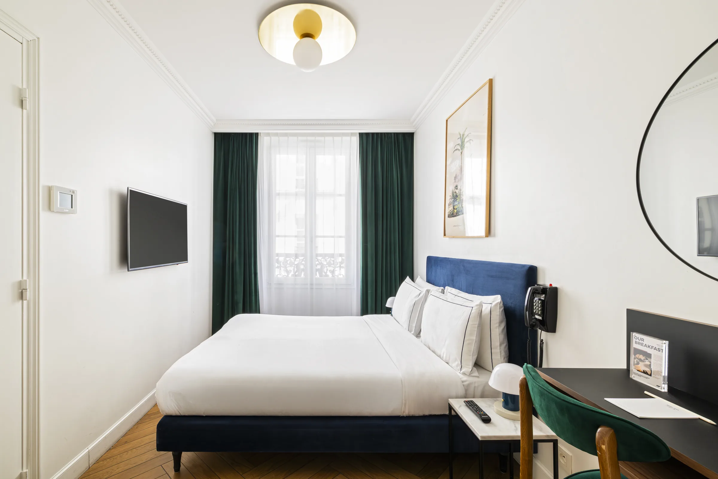 Chambre Supérieure parisienne avec tête de lit bleue et moulures