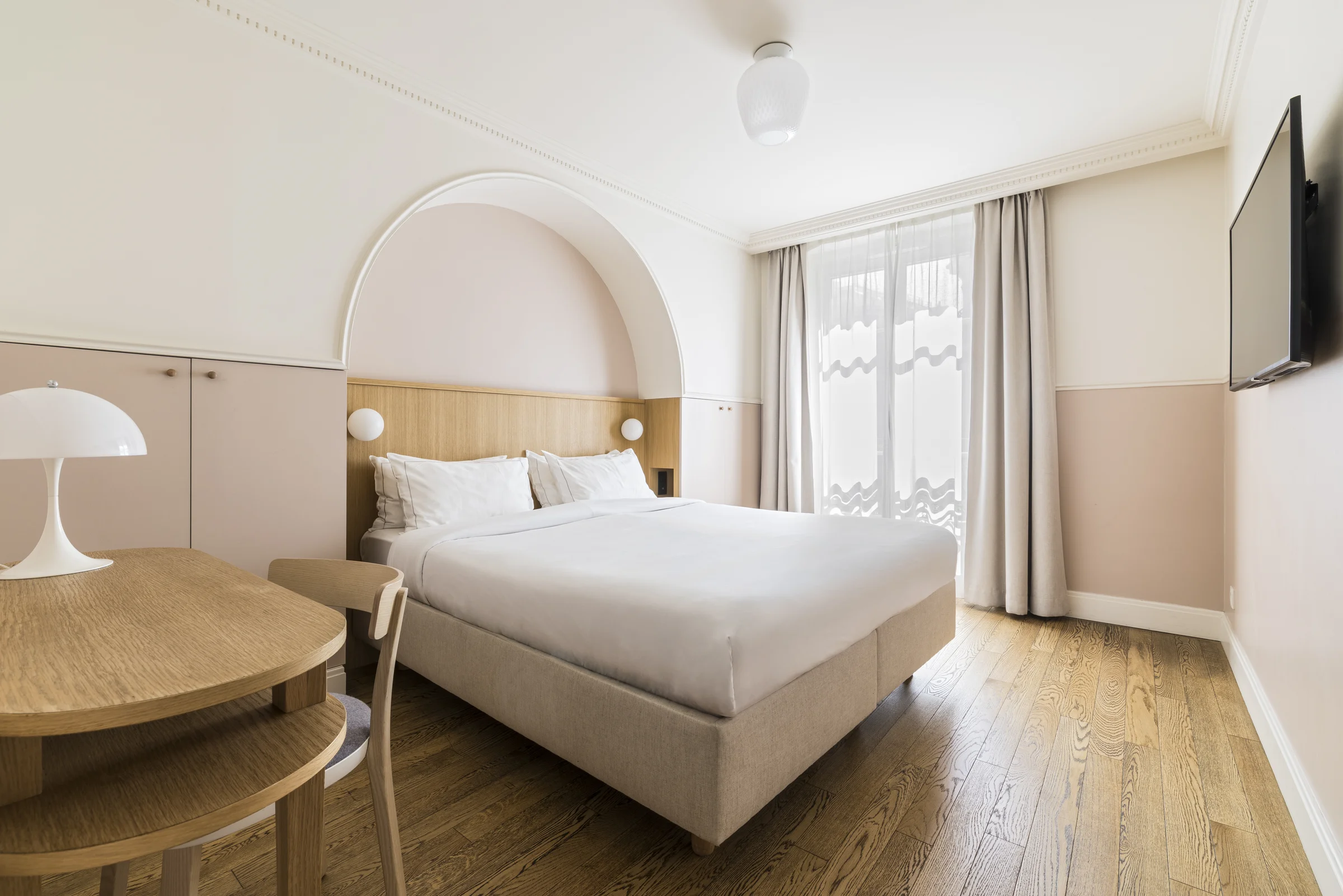 Chambre Supérieure de l'Hôtel Oratio, vue large avec arche rose, lit king size et fenêtre