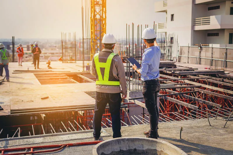 Construction site inspection with engineers wearing helmets and safety vests