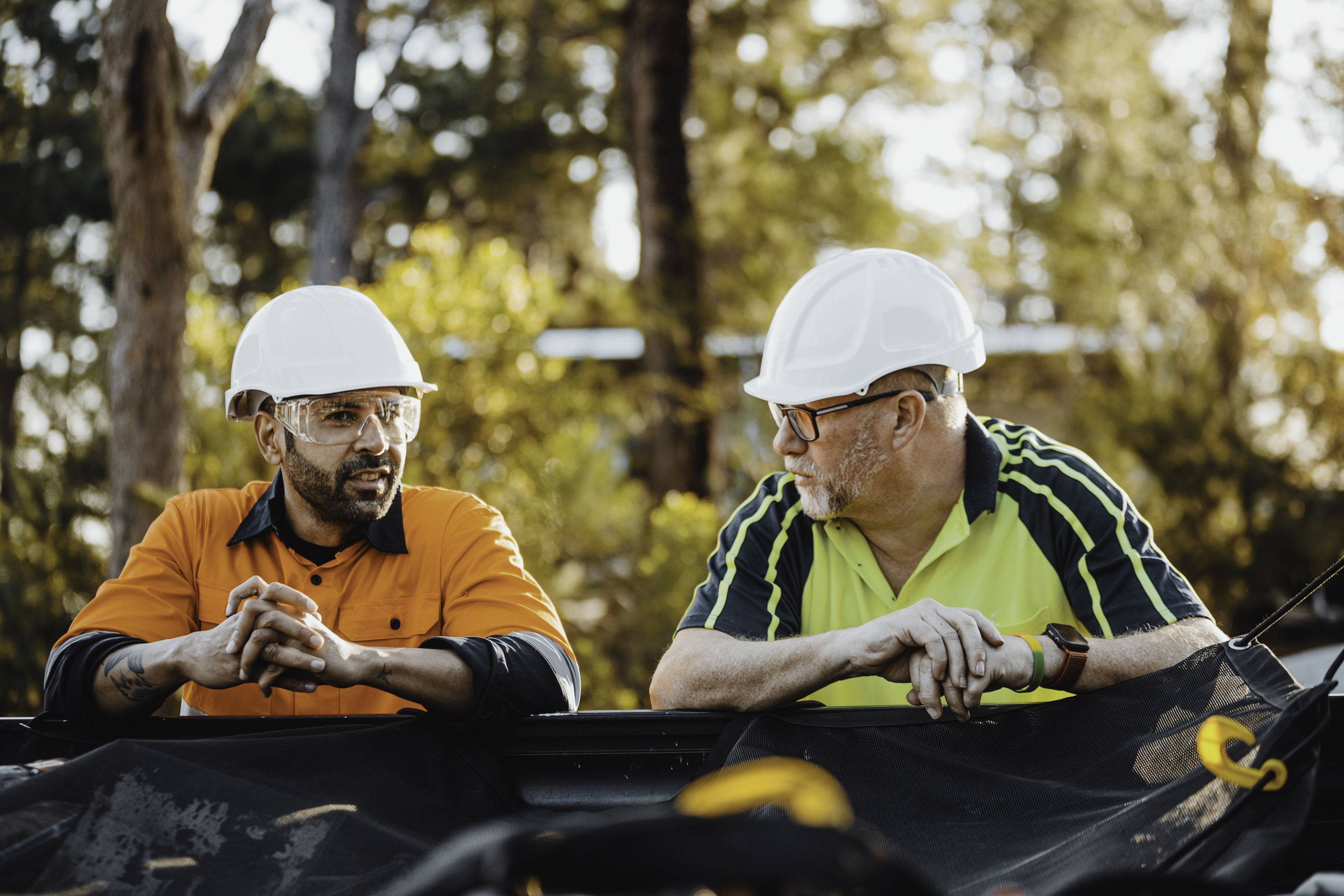 two construction workers talking to one another 