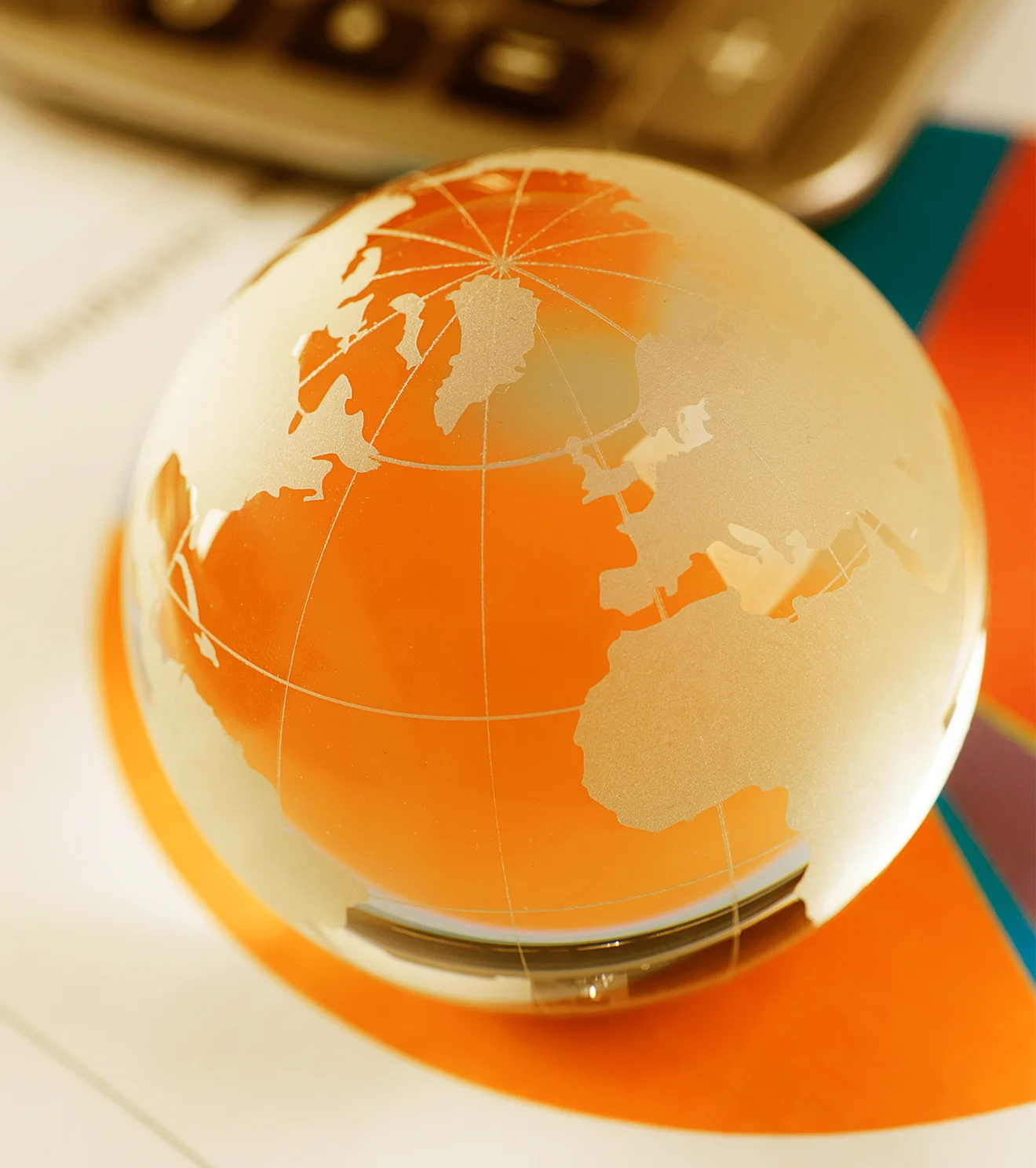 Glass globe resting on financial documents, symbolising global market insights and strategic forecasting for precise investment actions.