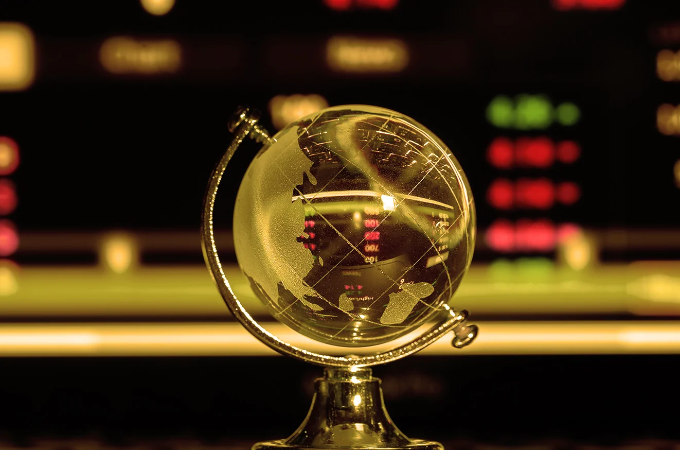 Transparent glass globe reflecting financial data, symbolising global financial insights and market alignment.
