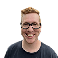 Smiling man with short light brown hair wearing black glasses and a dark shirt.