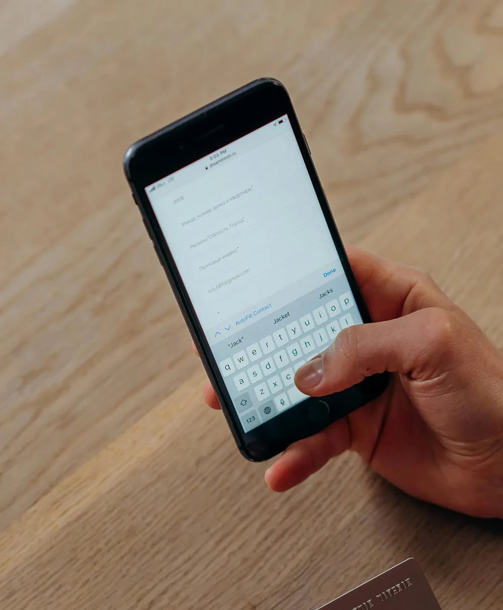 Photo of someone holding a phone and a credit card.