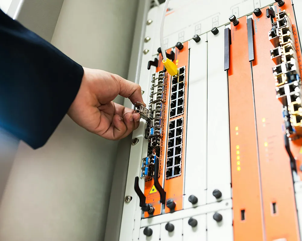 Picture of the hand of a man reaching for a server stack.