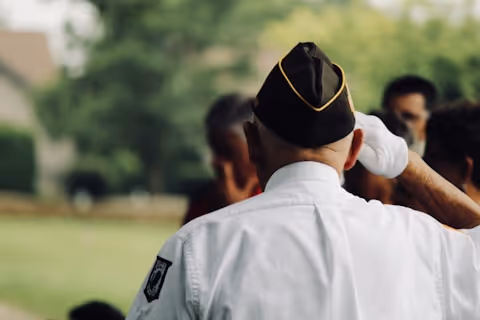 A veteran saluting during a memorial event, honoring those who served.