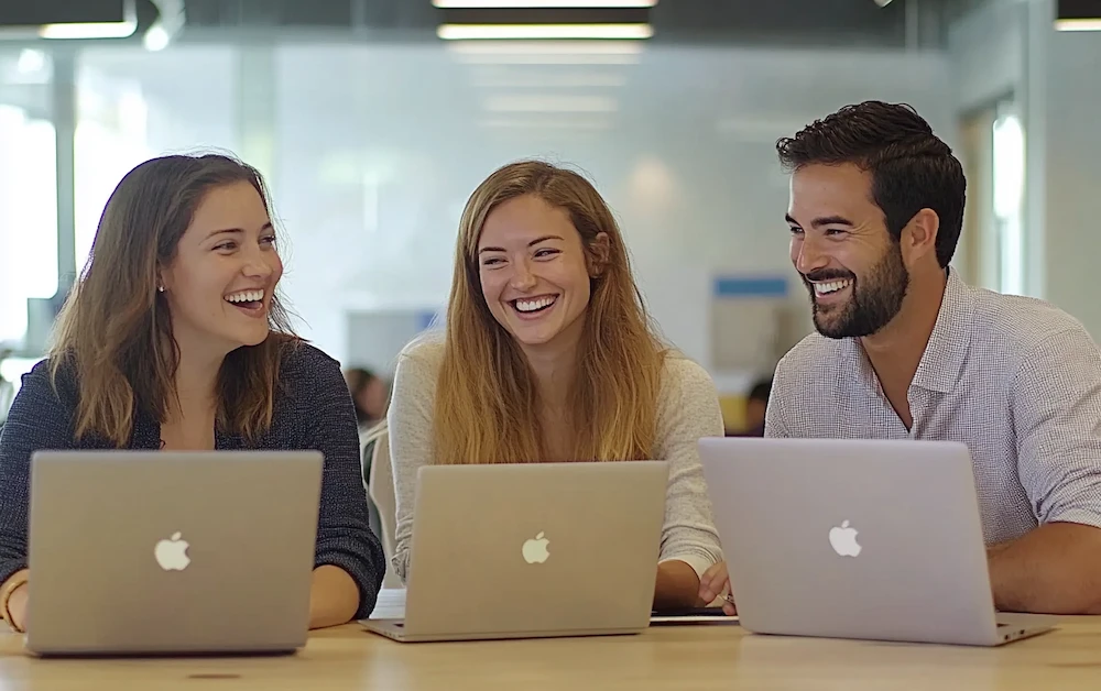 Team collaborating on laptops in a modern office environment, discussing process optimization tools to improve efficiency and workflow management.