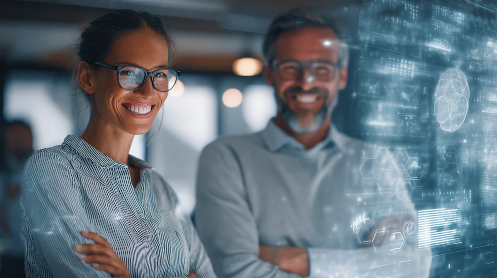 Business professionals smiling in a modern office with digital data visualization, representing strong data governance practices and effective data management strategies.
