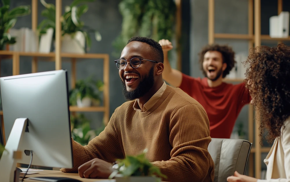 Team celebrating success with office automation tools, boosting productivity and efficiency. Happy employees using automated workflows on a computer in a modern office.