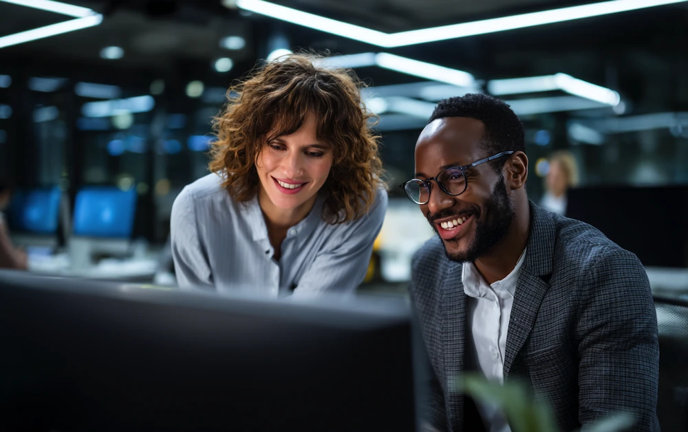 Finance professionals using accounts receivable automation solutions in a modern office setting, analyzing real-time data on a computer screen to streamline invoice processing and improve cash flow.