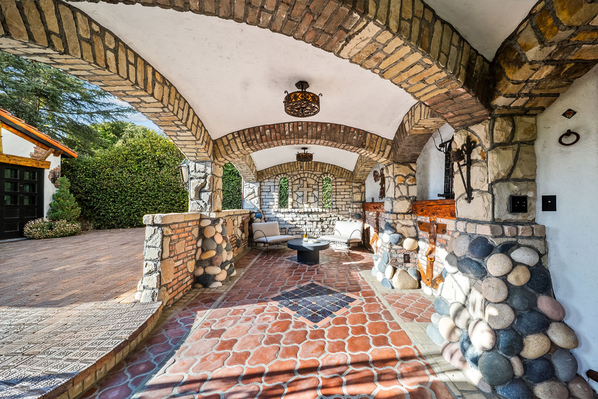 An arched patio is tucked beneath the hillside house.