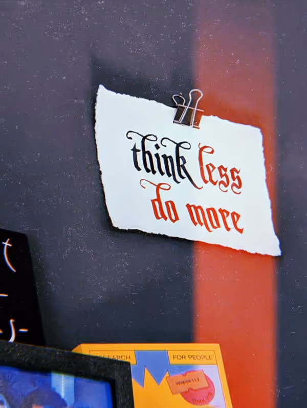 Ein Zettel hängt an der Wand, auf ihm steht. "Think less do more"