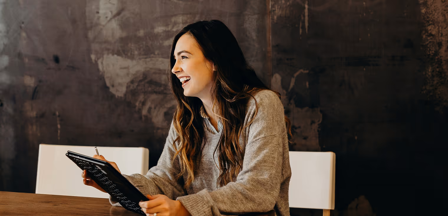 Woman smiling holding a tablet