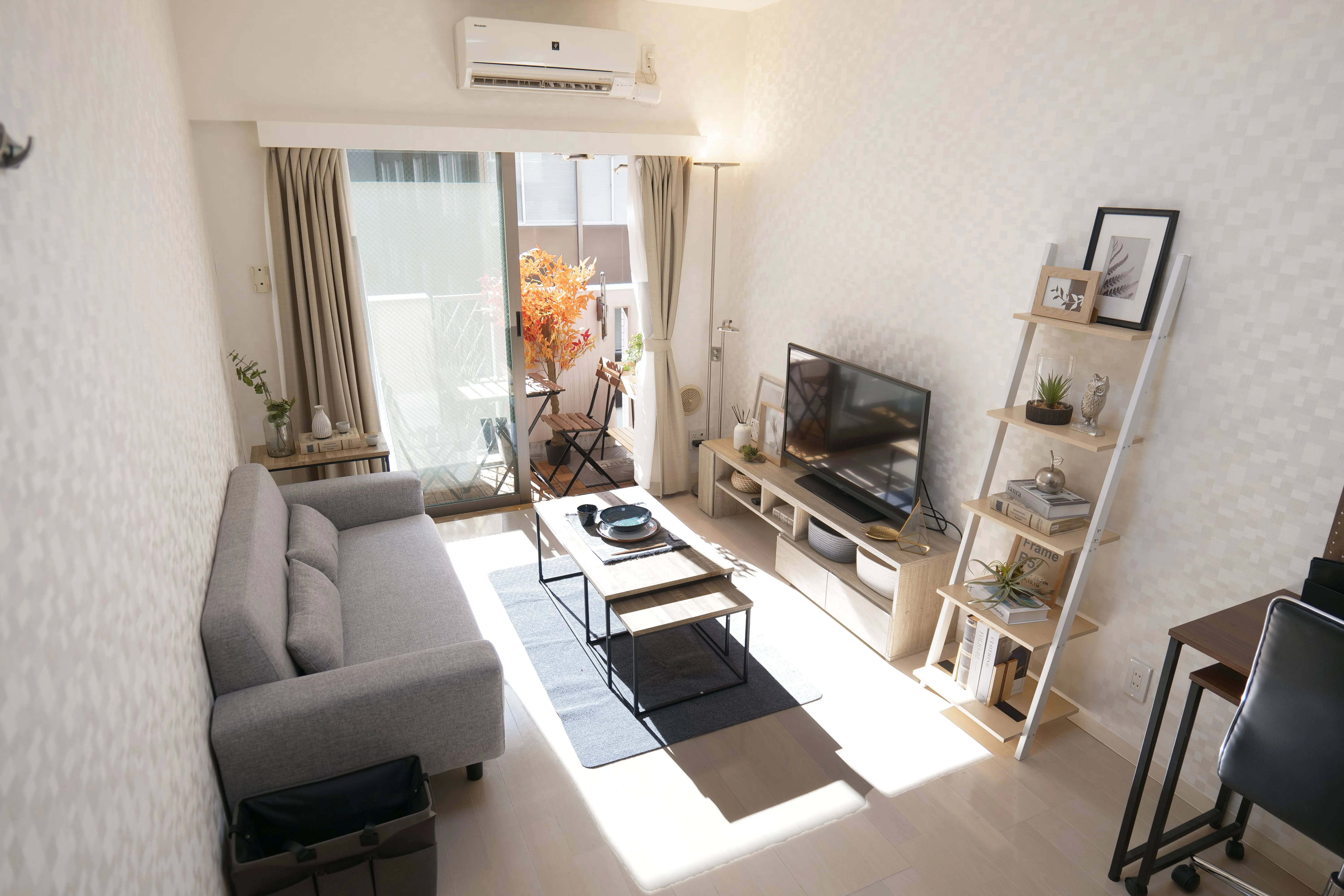 Cozy room with veranda, 2-seater sofa, center table, and flat-screen TV.
