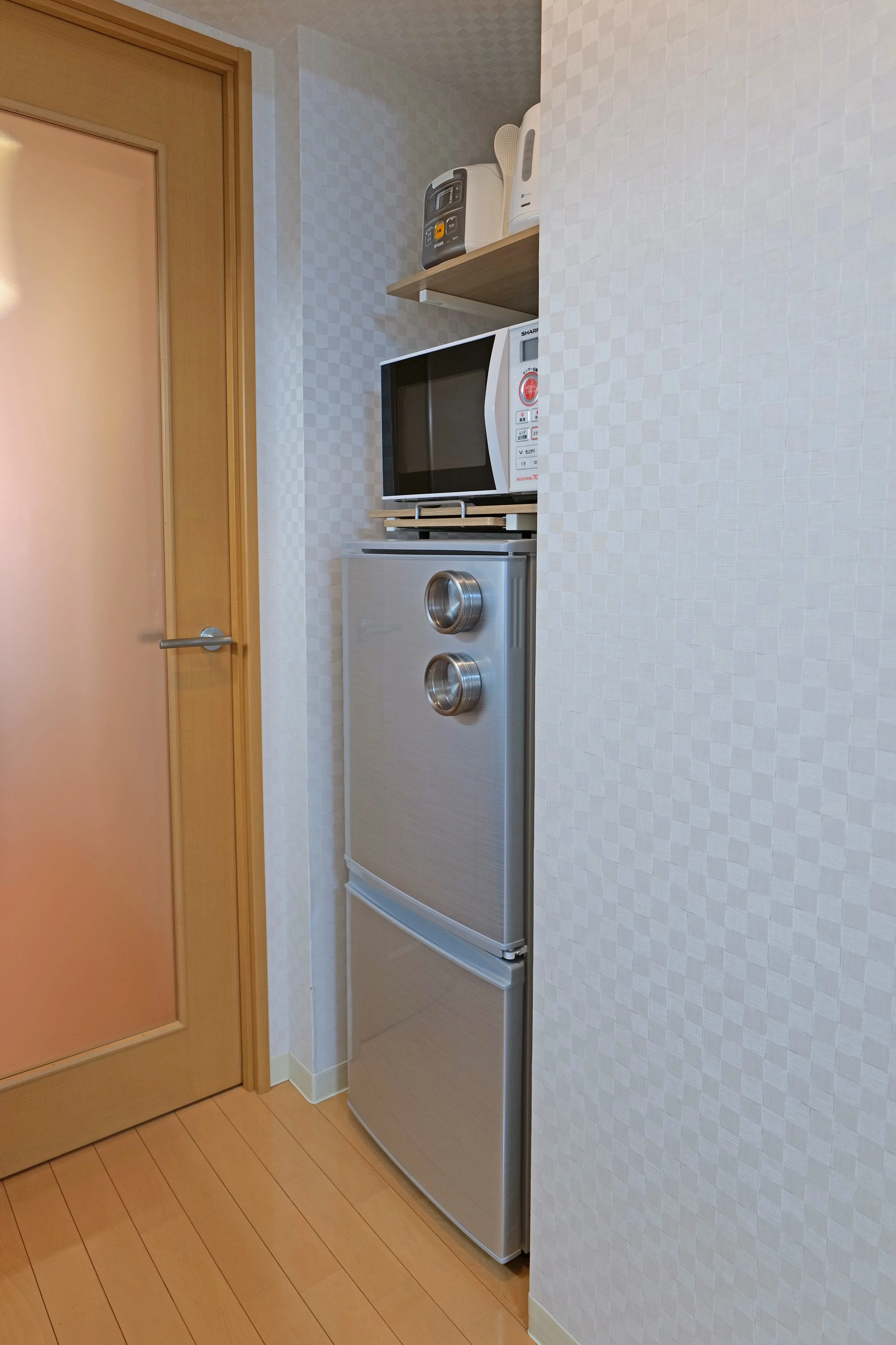Refrigerator with freezer and microwave placed on top.