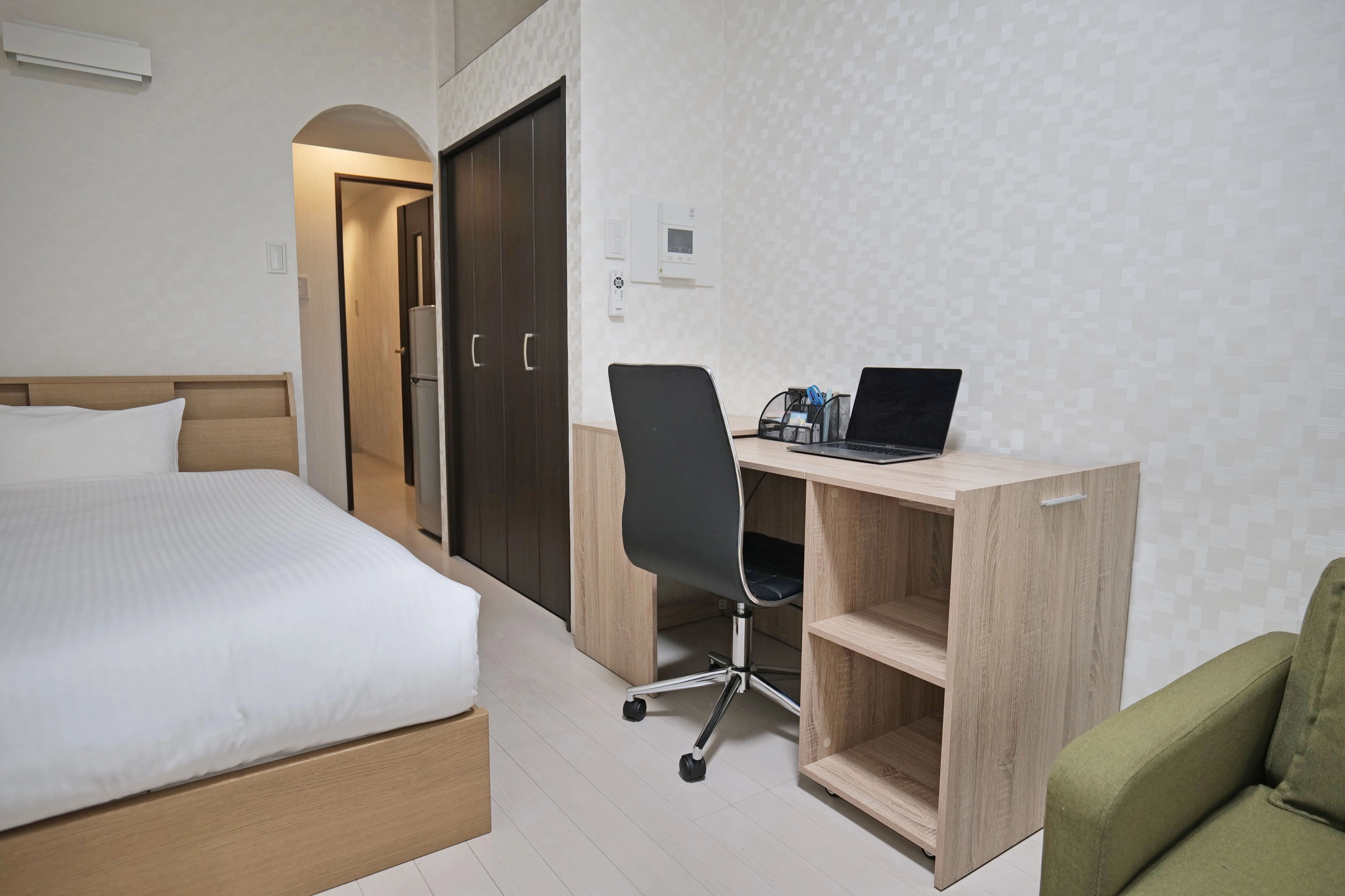 Cozy small bedroom with a semi-double bed, wooden floor, TV stand, and center table for comfortable city living.