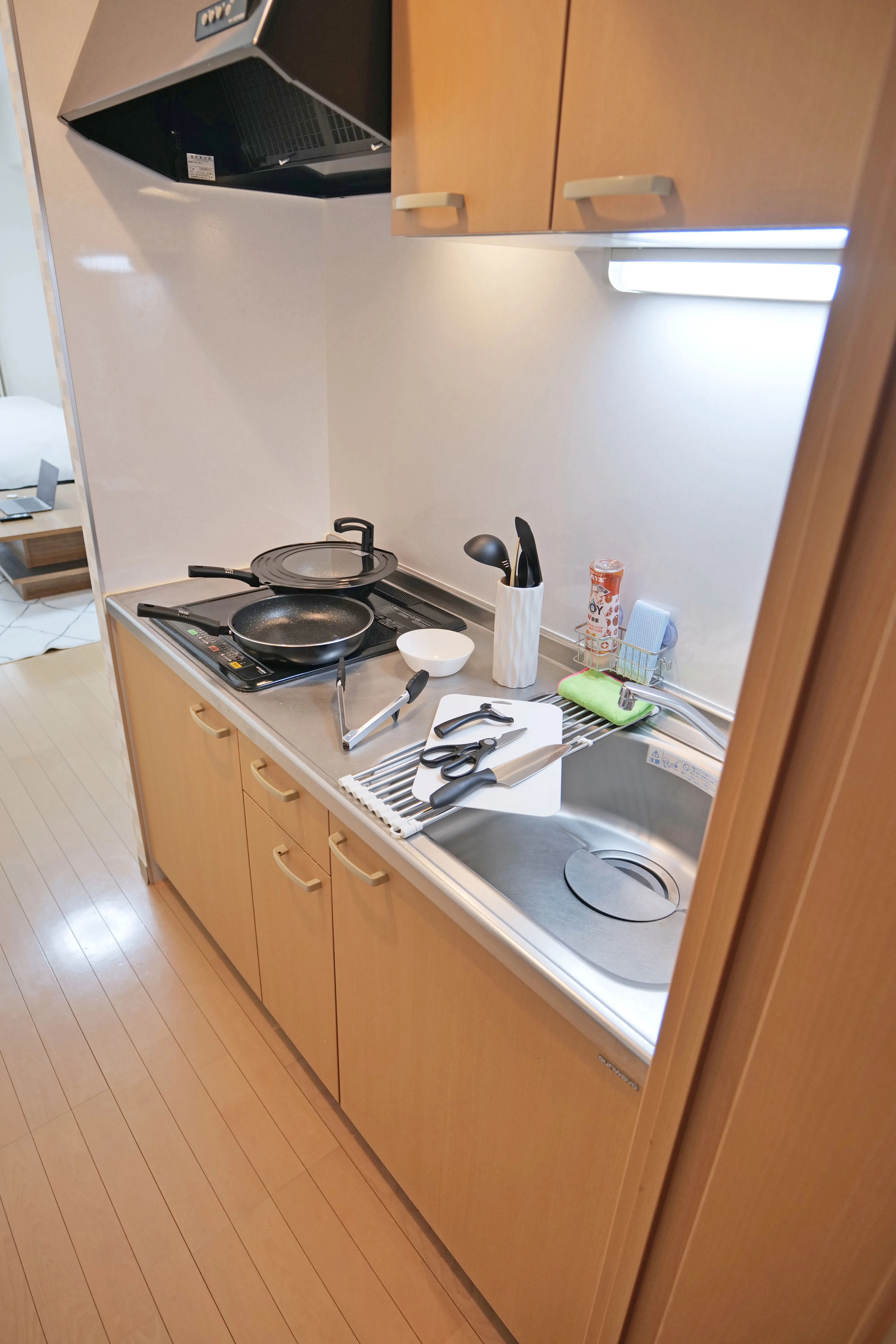 Compact yet functional kitchen with top and bottom drawers, complete cooking utensils, pans, and kitchen tools — perfect for preparing meals just like home.