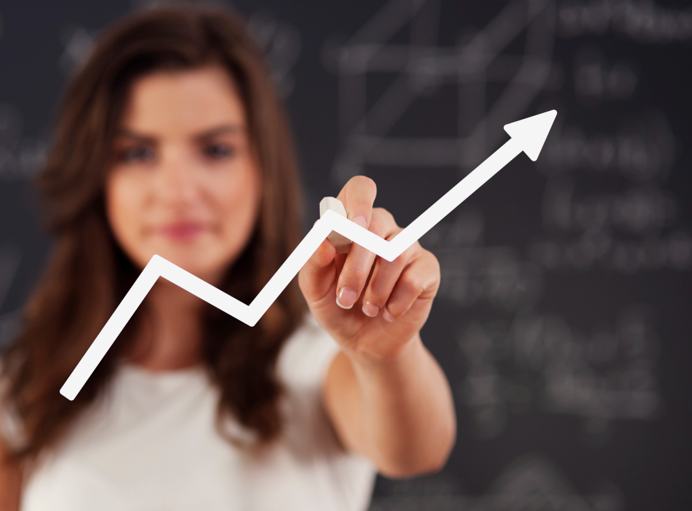 A woman pointing at a graph with an upward trend, symbolizing success in lead generation.
