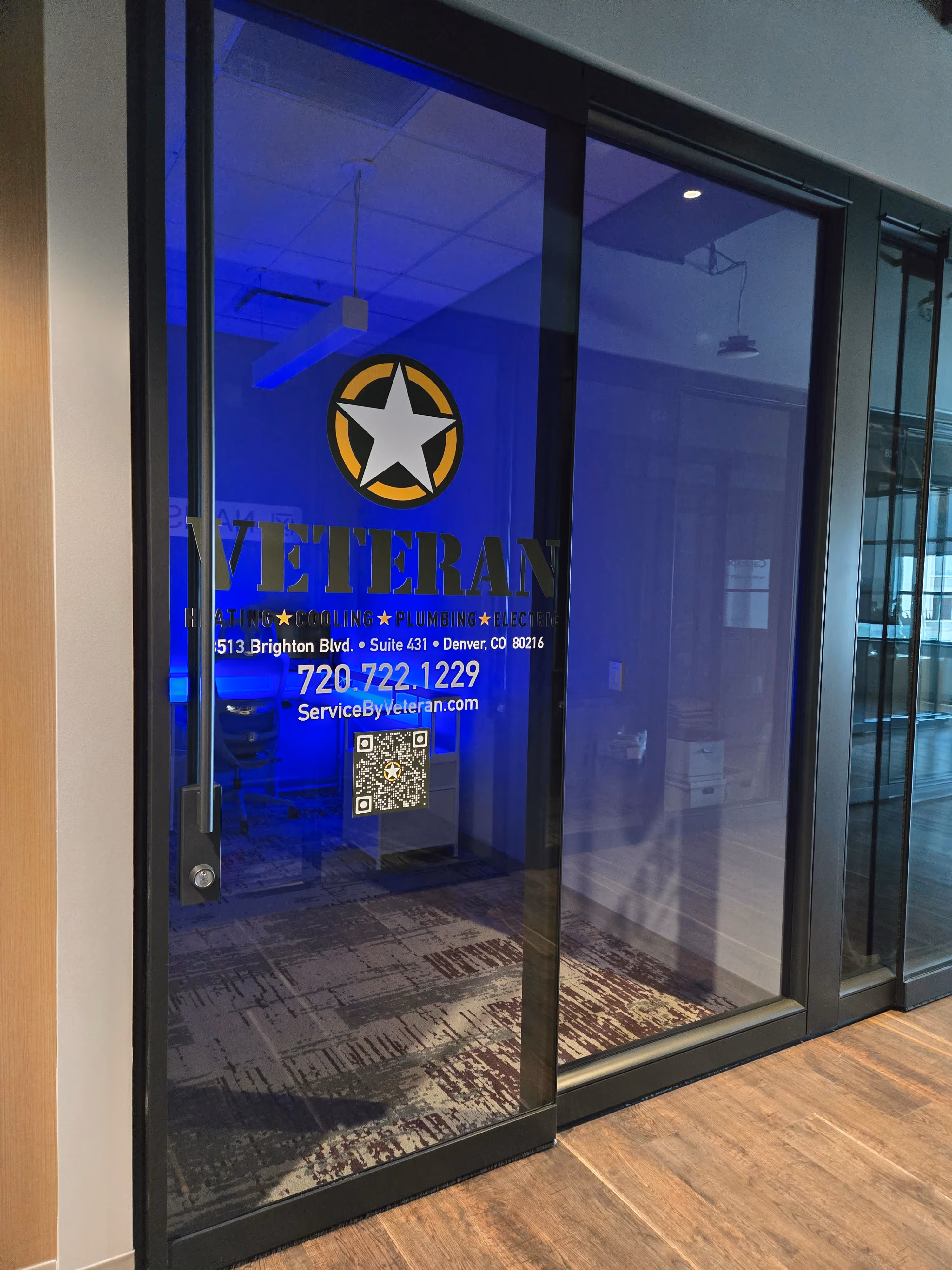 Glass office door with "Veteran" and a star logo. Includes contact info and QR code.