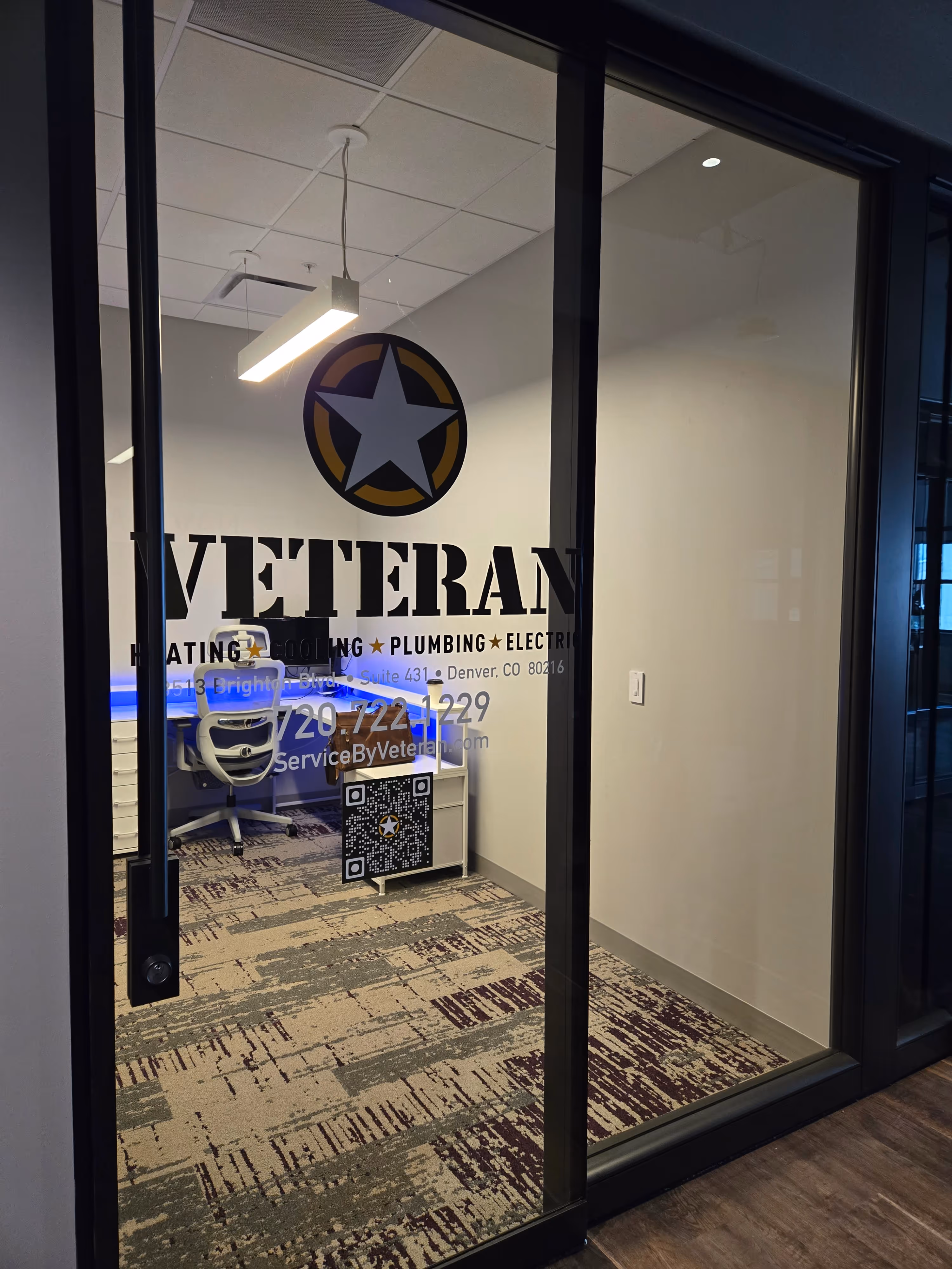 Office with glass door displaying "Veteran," a logo with a star, and service details. 