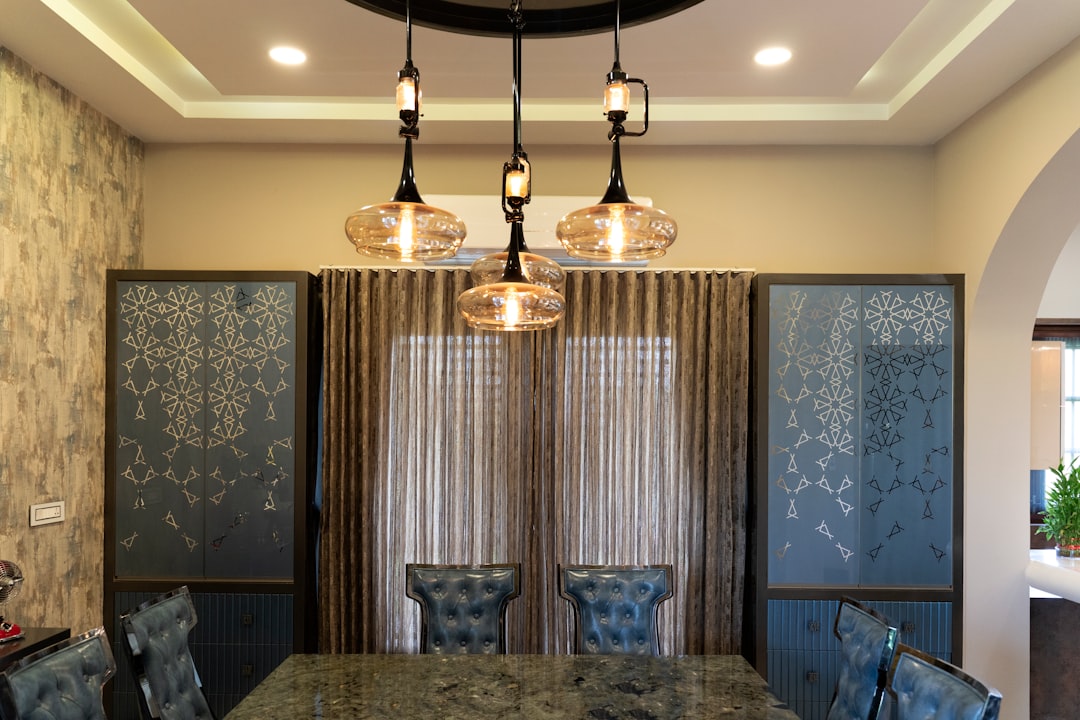 comedor elegante con un candelabro y luces empotradas - instalación del sistema de iluminación