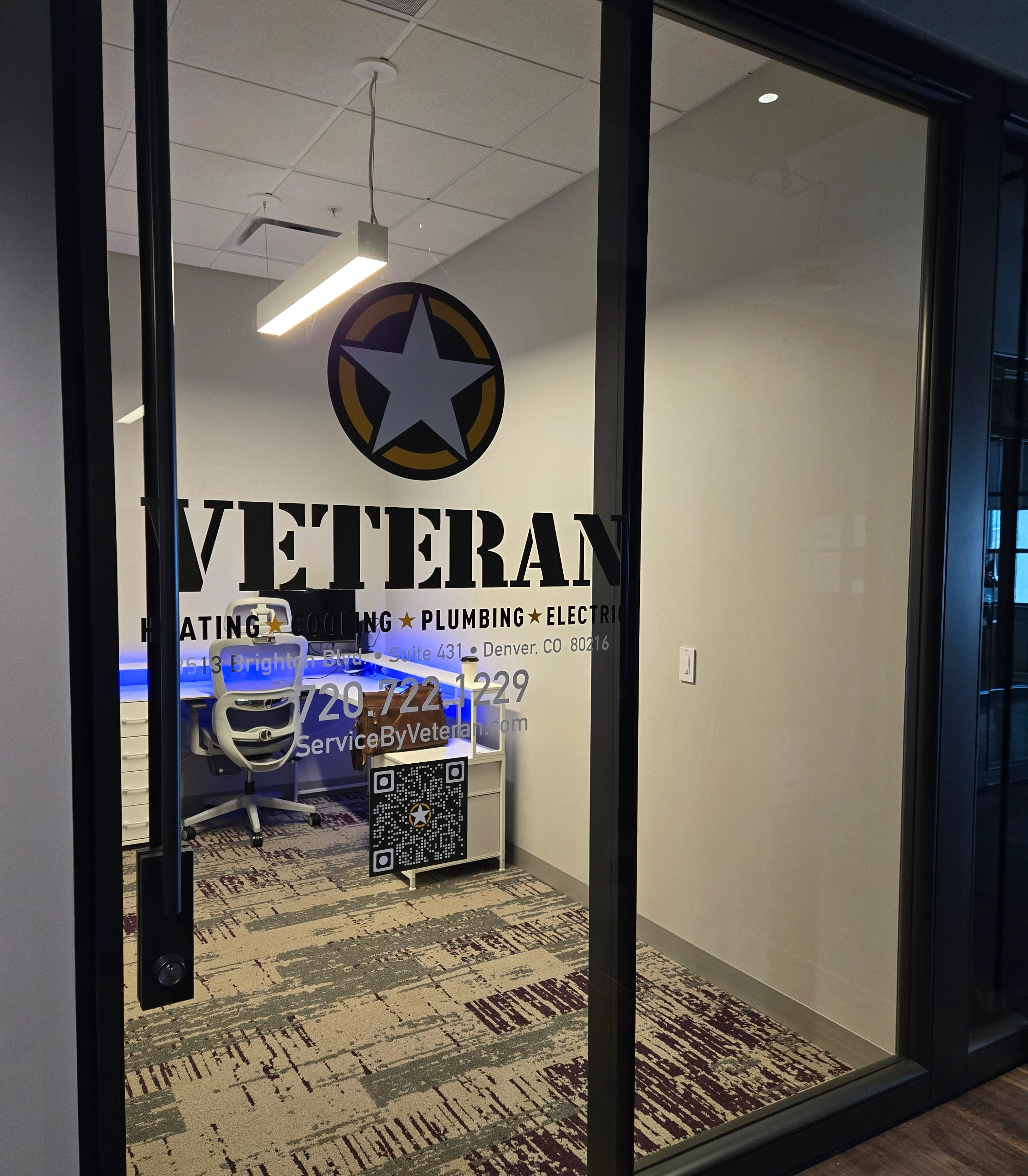 Puerta de oficina de vidrio con la palabra "VETERANO" y un logo de estrella.