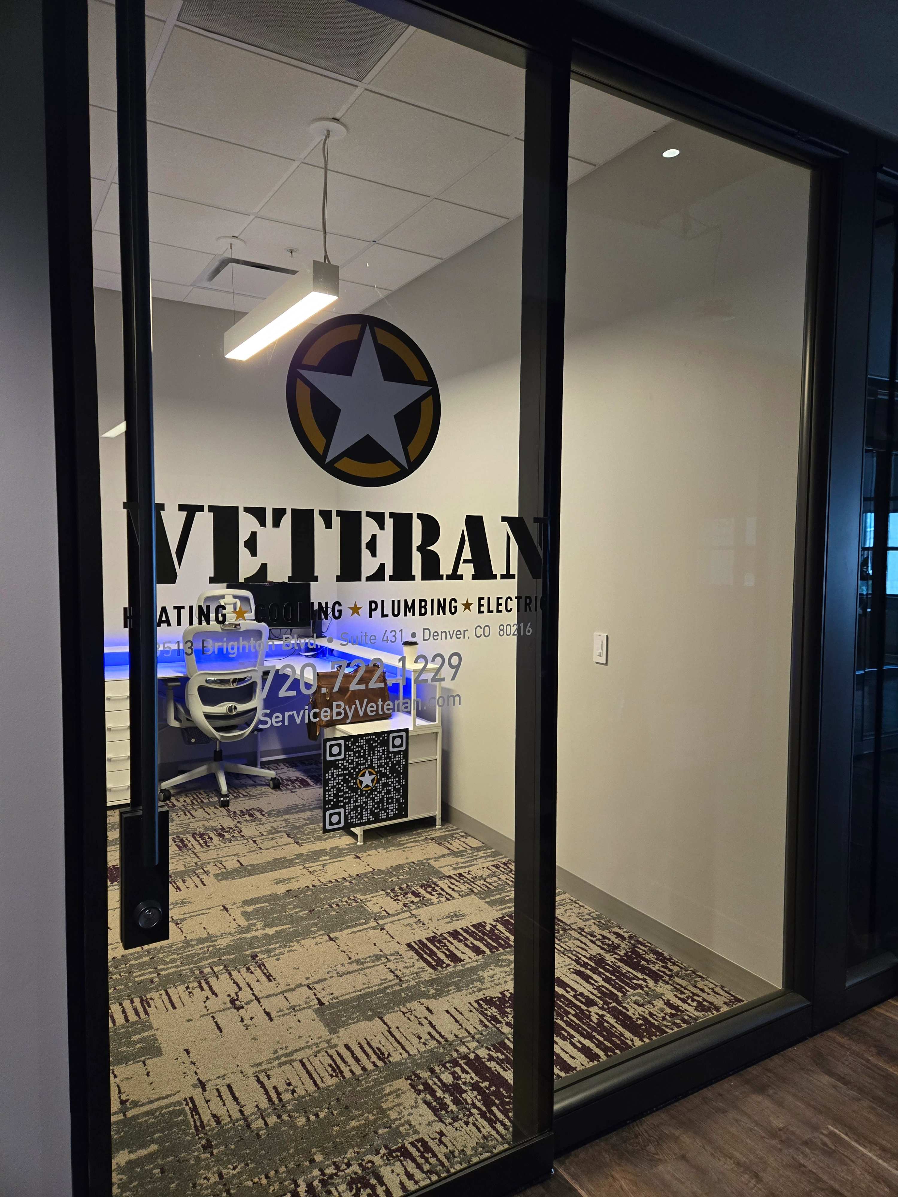 Oficina con puerta de vidrio que muestra "Veterano," un logo con una estrella, y detalles del servicio.