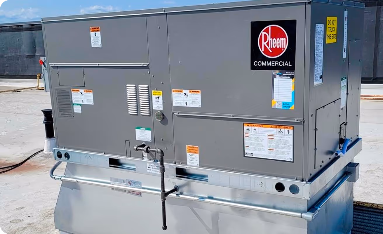 A commercial Rheem HVAC unit is installed on a rooftop, surrounded by safety and operation labels.