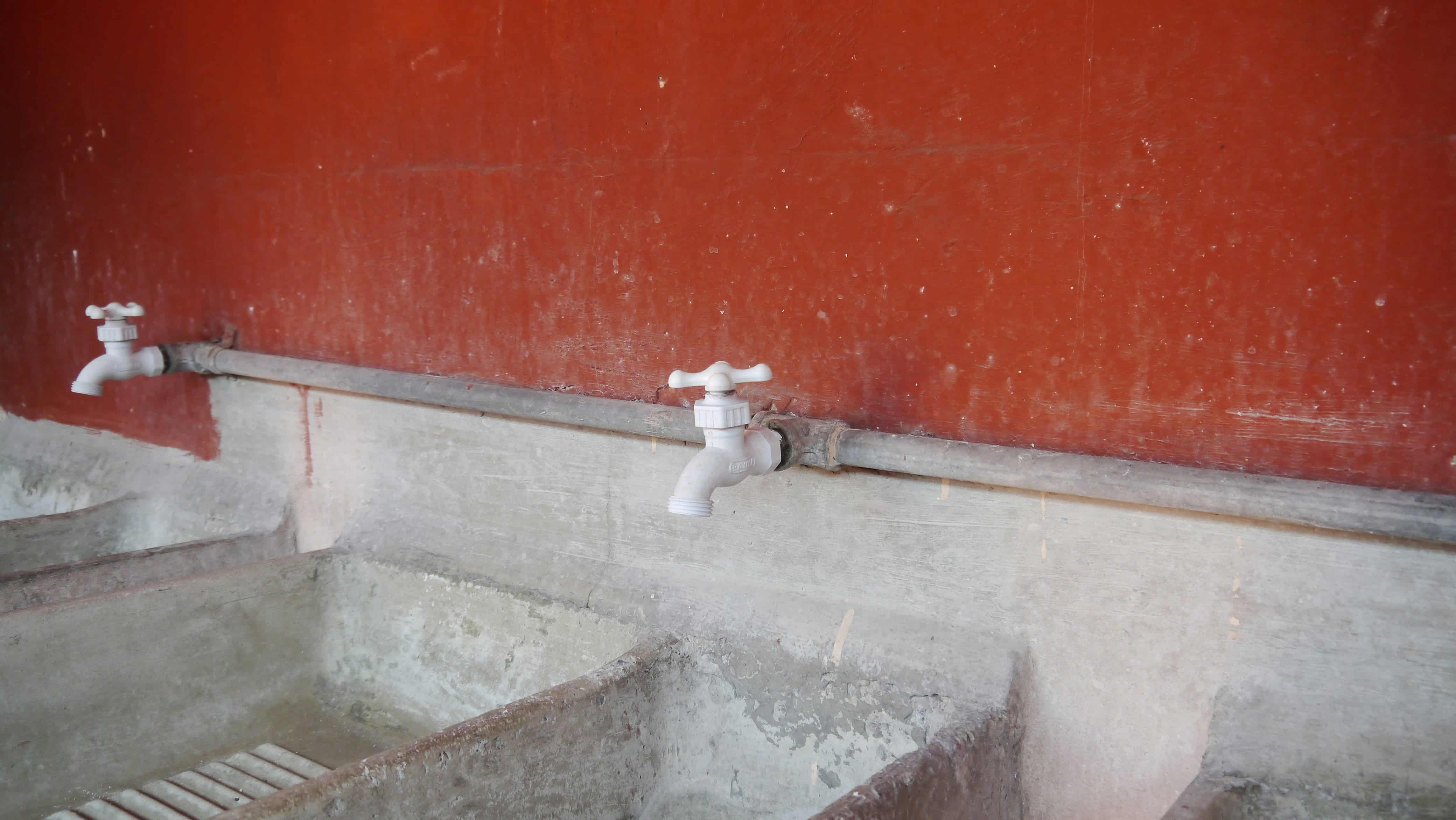Water.Day_faucets in front of a red wall
