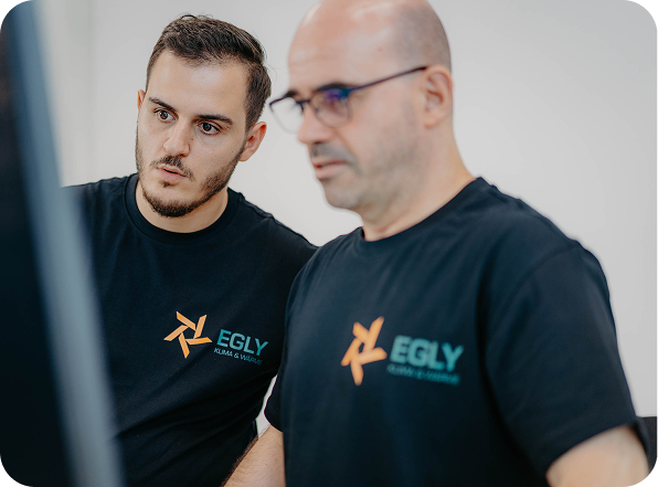 Zwei Egly Mitarbeiter schauen auf einen PC.