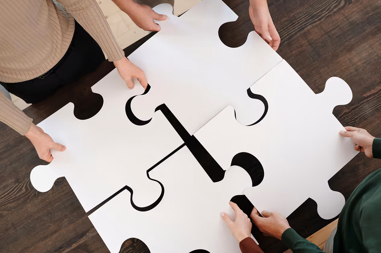 Close-up of hands fitting puzzle pieces together.