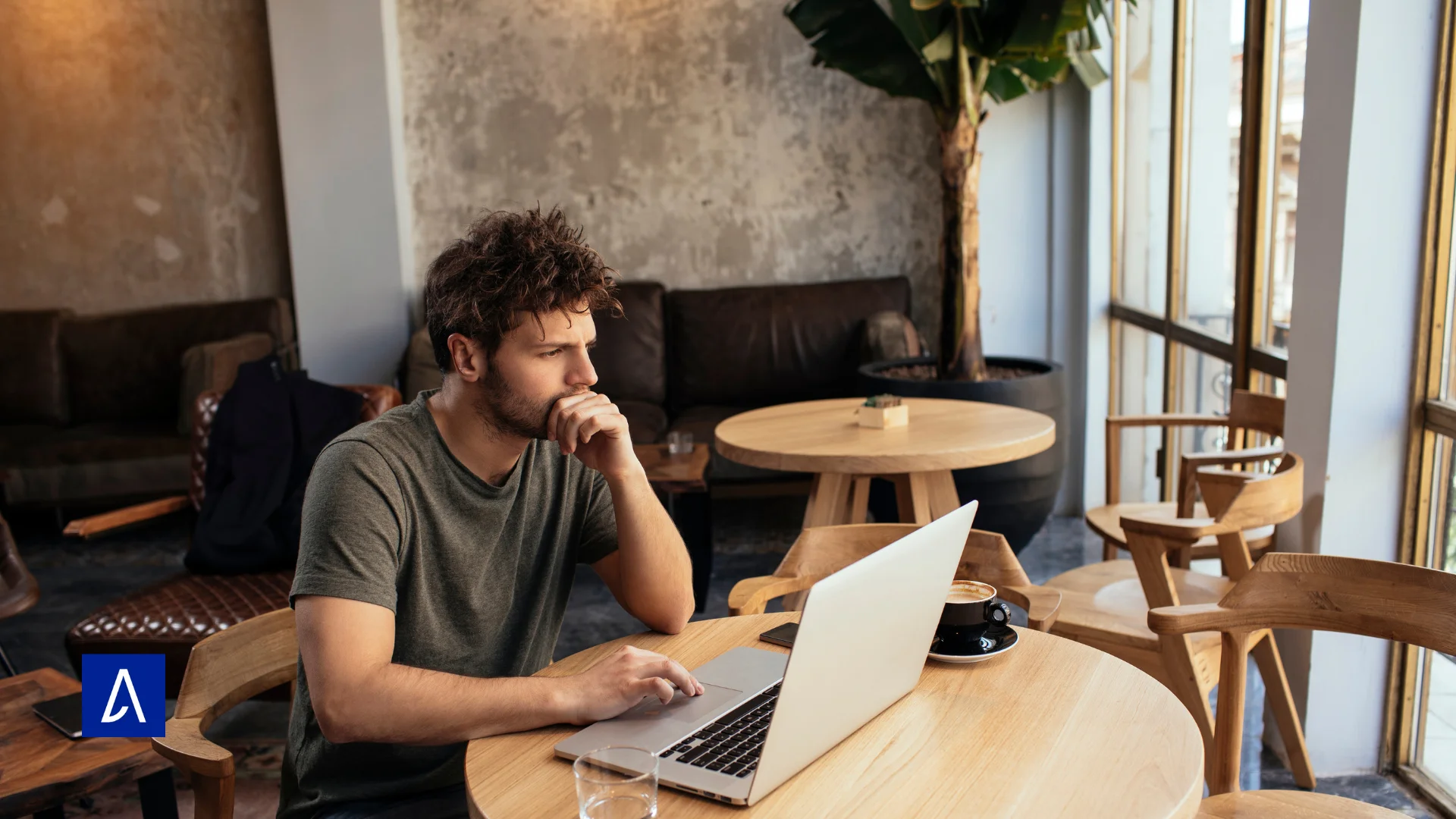 Homme travaillant sur un ordinateur portable dans un café avec tasse de café sur la table
