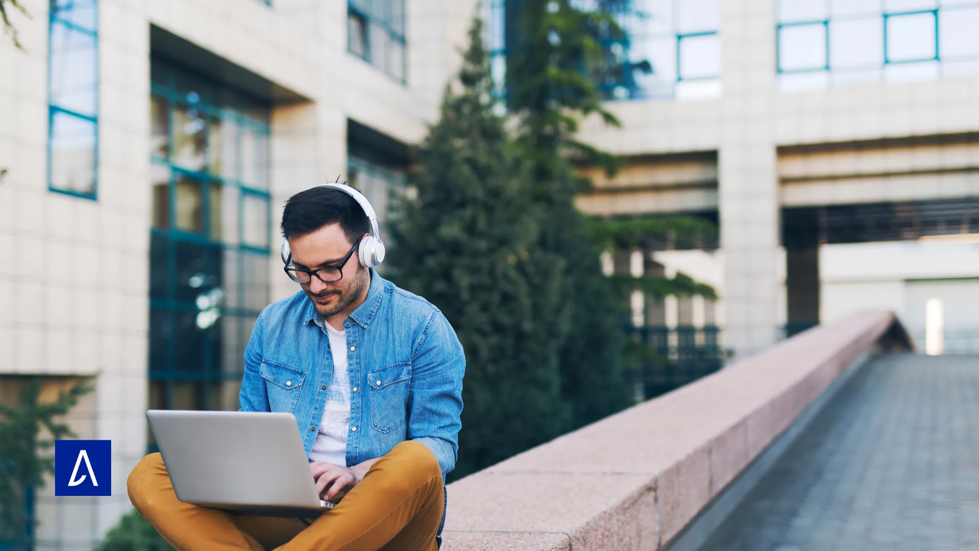 Copywriter suivant une formation en ligne avec son ordinateur portable et un casque, en plein air.