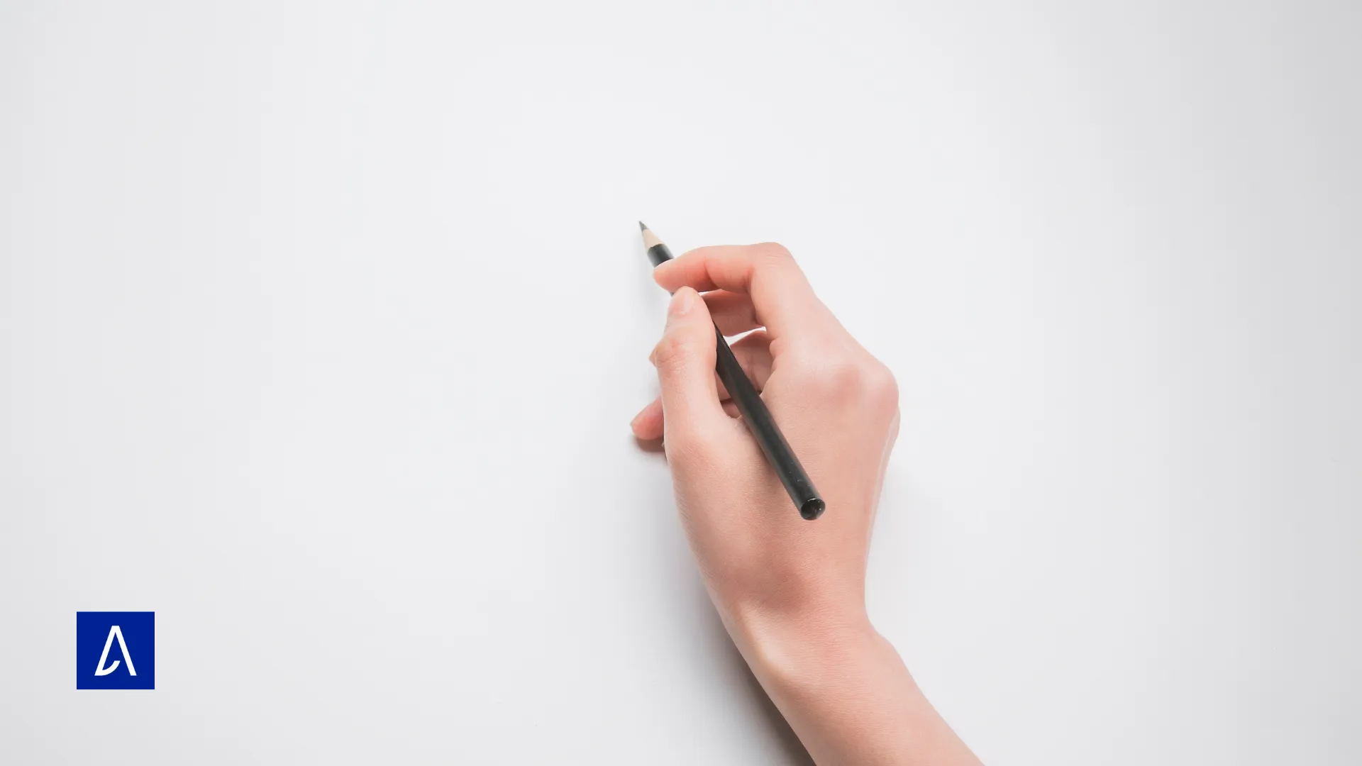 Main écrivant au crayon sur une feuille blanche – métaphore de la page blanche en copywriting.