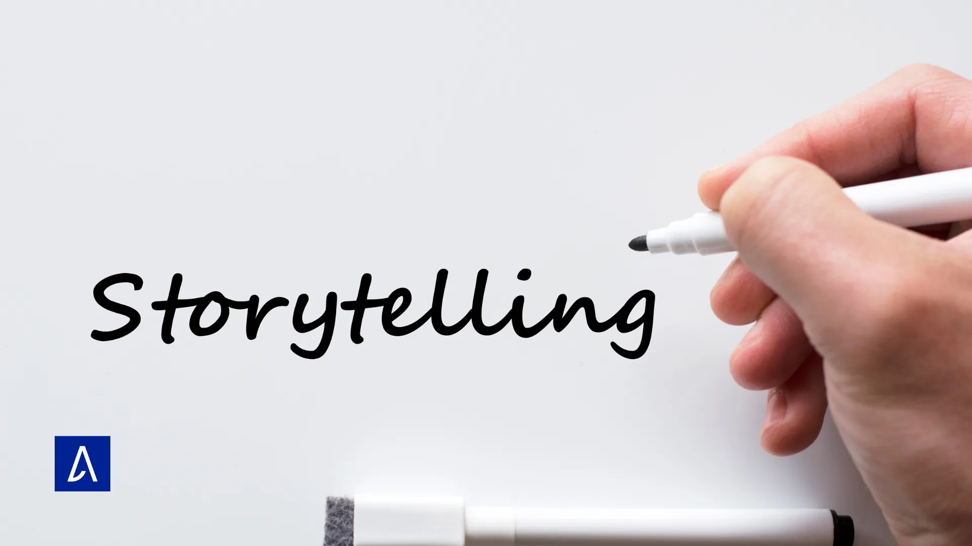Gros plan d’une main écrivant le mot « Storytelling » au marqueur noir sur un tableau blanc.
